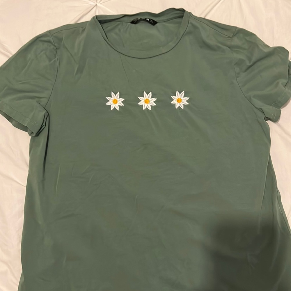 Small t-shirt with three flowers on front. Green/blue color.